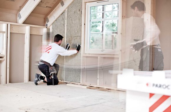Man-insulating-with-stonewool Lagom varmt både sommar och vinter med isolering från Paroc och tätskikt från T-Emballage